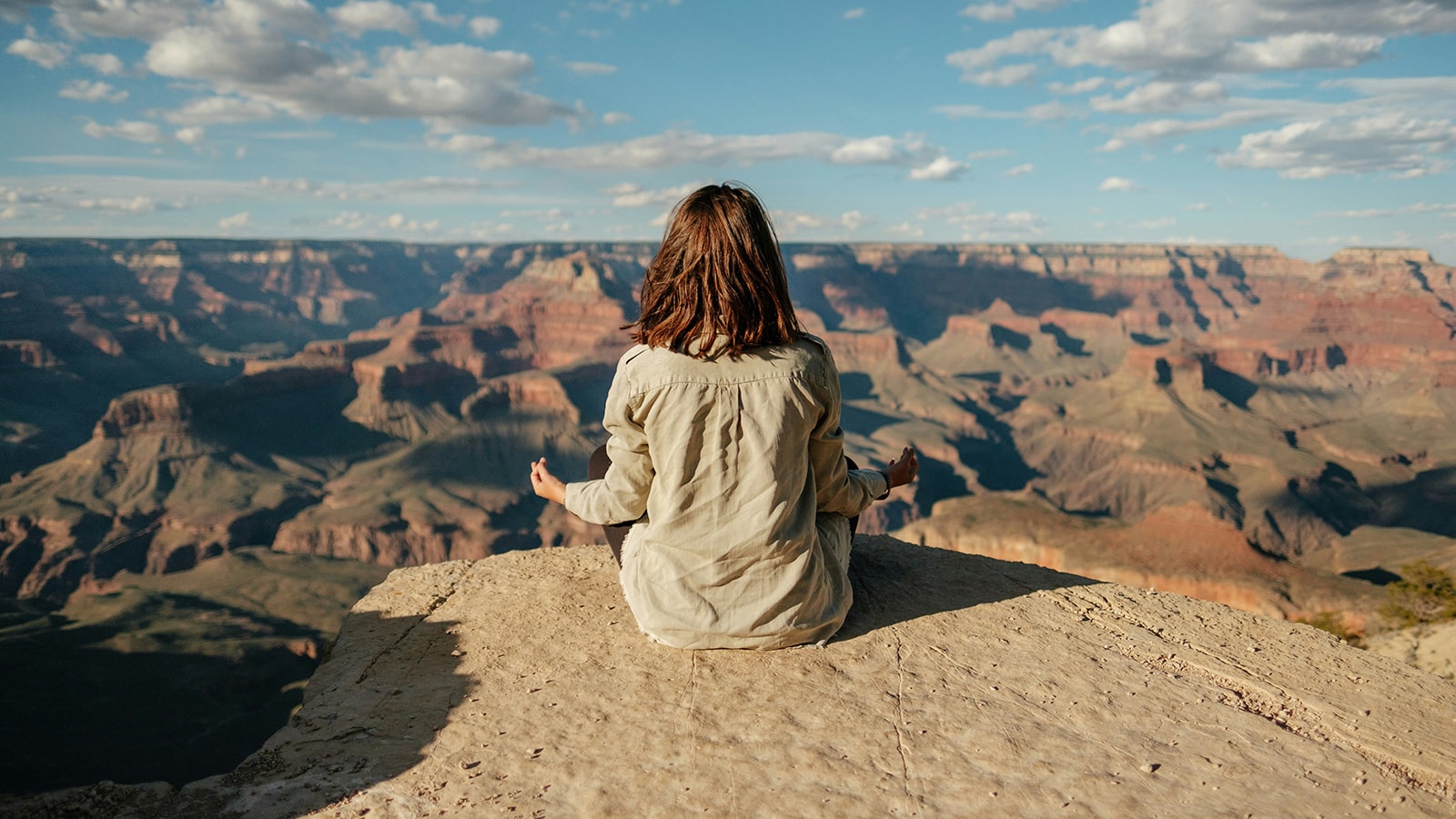 woman meditating near canyon